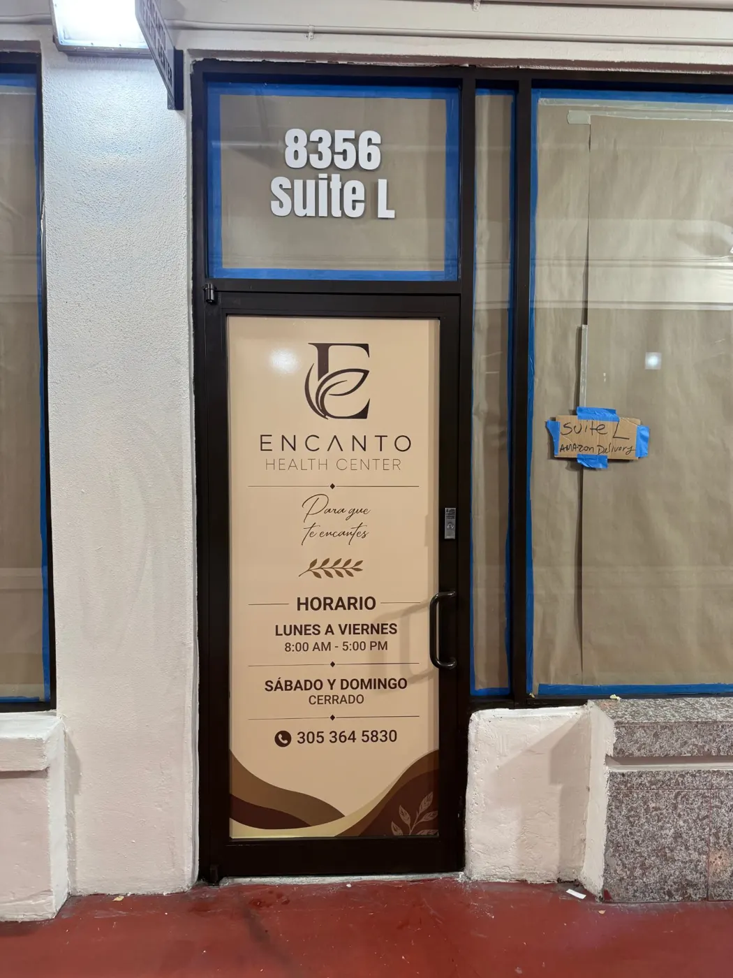 Puerta de Encanto Health Center con número de suite, logo, horario y teléfono